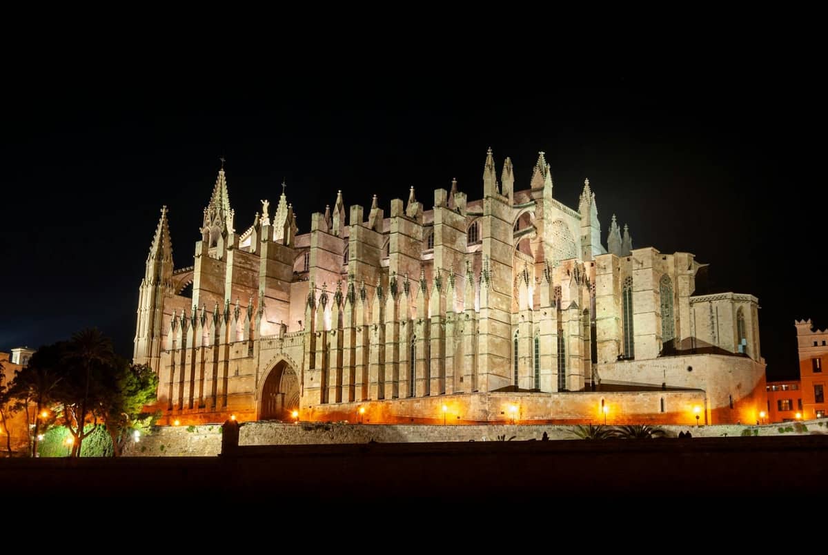 La Catedral de La Seu en Palma de Mallorca iluminada de noche con una iluminación espectacular, sobre un cielo oscuro.