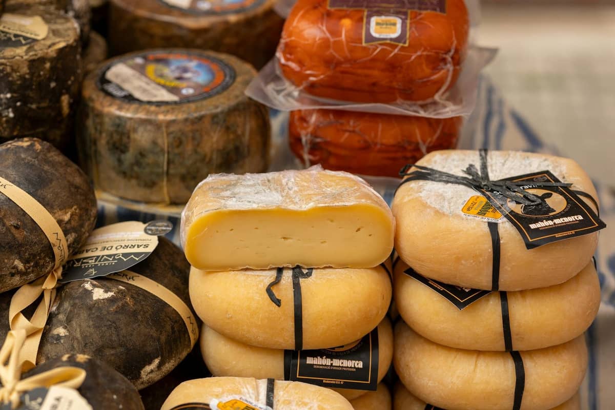 Close-up de queijos locais de Mallorca embrulhados e expostos numa mesa de mercado, prontos para comprar como produtos regionais autênticos.