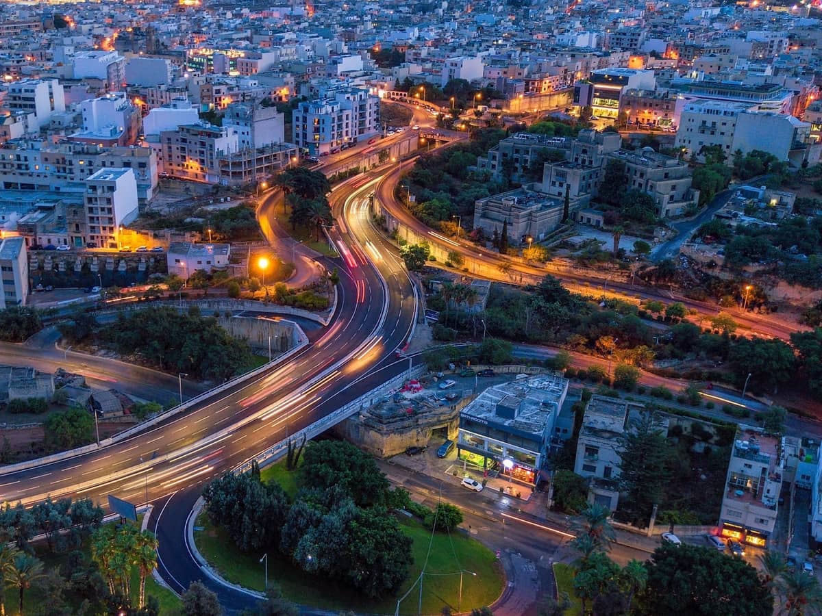 Góc nhìn trên không của cảnh quan thành phố Malta vào ban đêm với những con đường và tòa nhà được thắp sáng, cho thấy các khu vực vui chơi về đêm tập trung và địa lý đô thị.