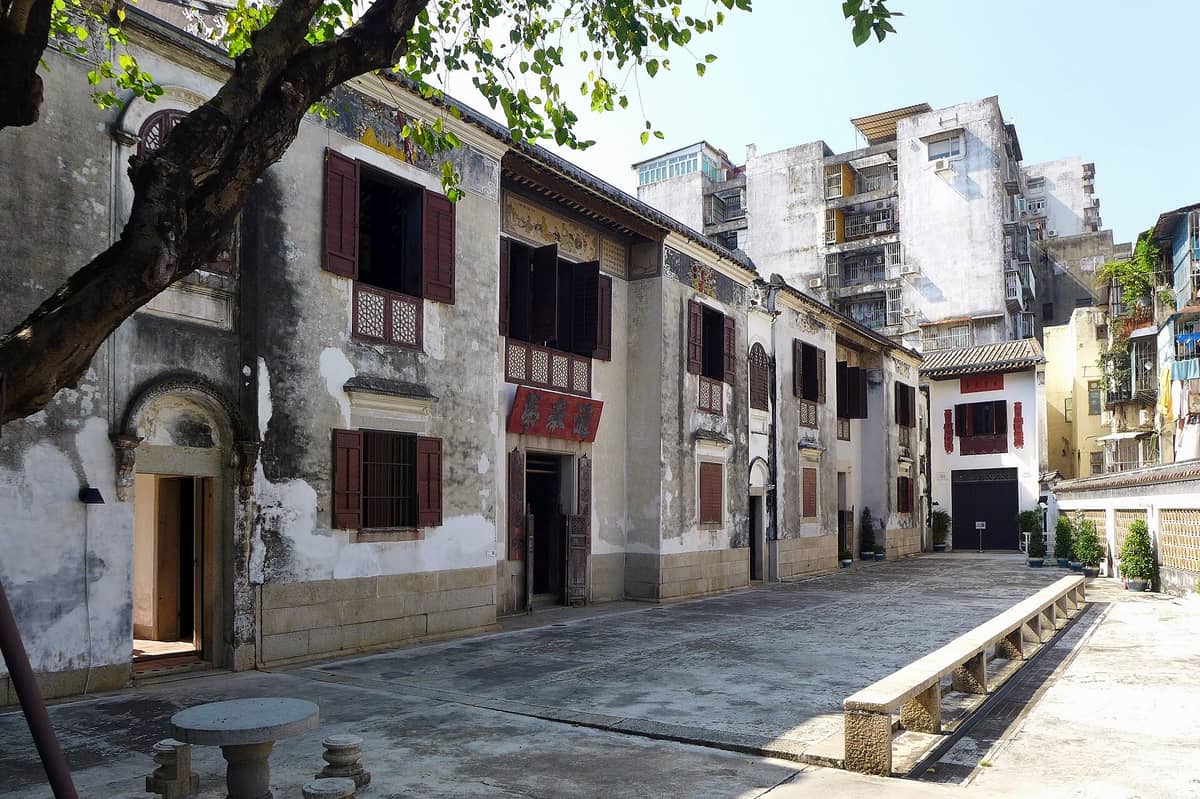 Ein weiter, sonnendurchfluteter Blick auf das historische Mandarin's House in Macau mit seiner Architektur der Qing-Dynastie, dem offenen Innenhof und den umliegenden alten Wohngebäuden.