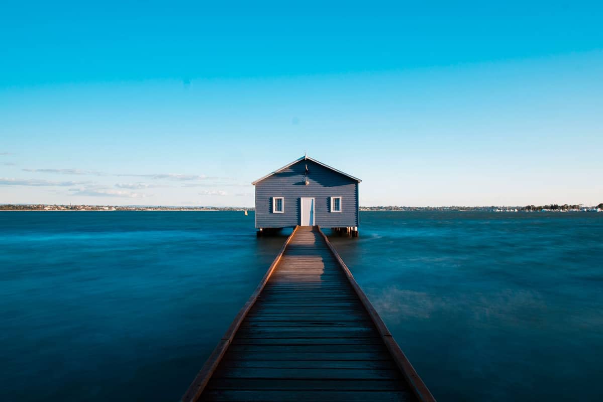 Das ikonische blaue Crawley Edge Bootshaus an der Matilda Bay in Perth steht am Ende eines langen Holzstegs, der über den Swan River hinausragt.