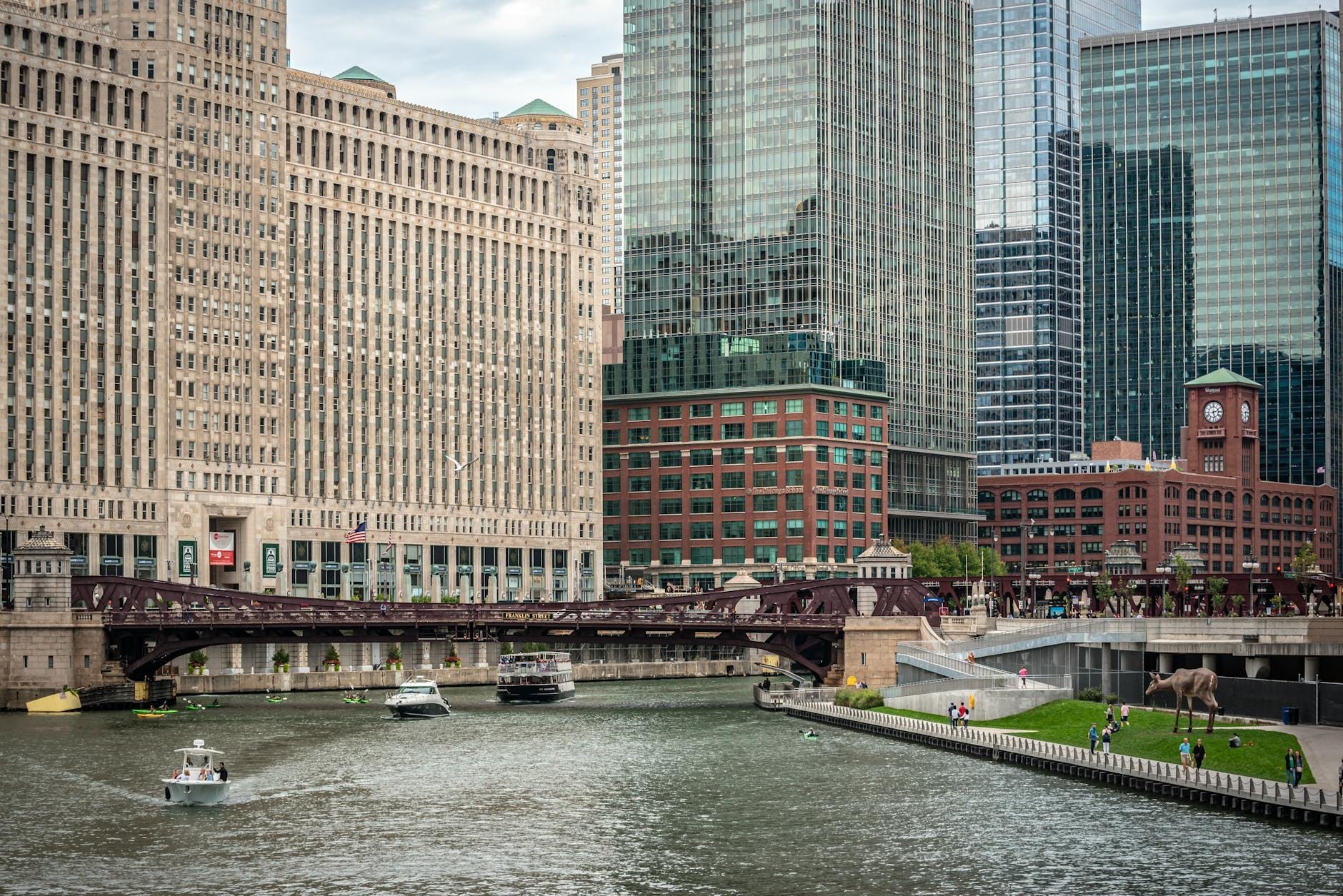 Il Merchandise Mart si erge imponente lungo il Chicago River, con imbarcazioni sull'acqua e grattacieli moderni che circondano il monumento nel centro di Chicago.