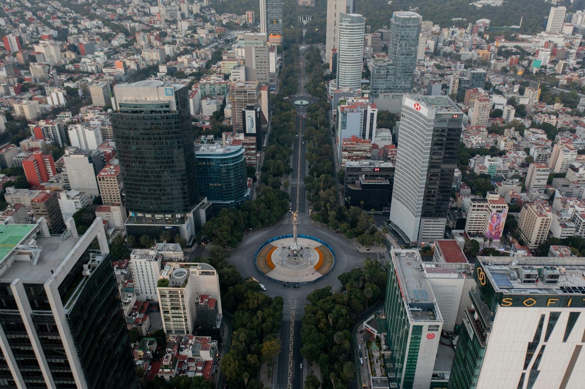 Vista aérea do Paseo de la Reforma na Cidade do México, mostrando hotéis de luxo e edifícios de escritórios ao redor do monumento do Anjo da Independência.