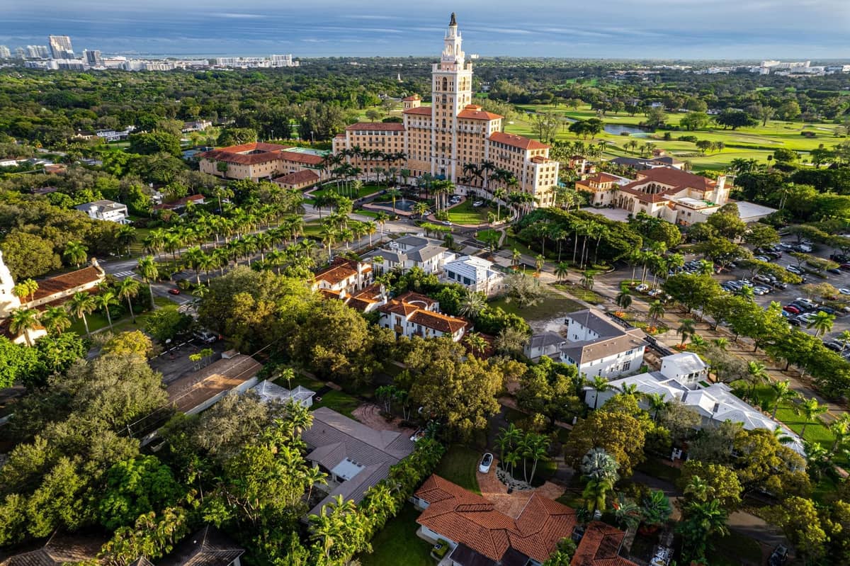 Aerial view of the historic Biltmore Hotel in Coral Gables, surrounded by lush greenery and historic buildings.