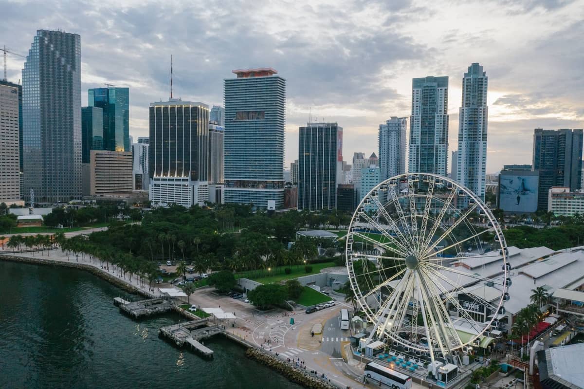 Aerial view of Bayfront Park in downtown Miami with the large Ferris wheel, the waterfront, and skyscrapers in the background.