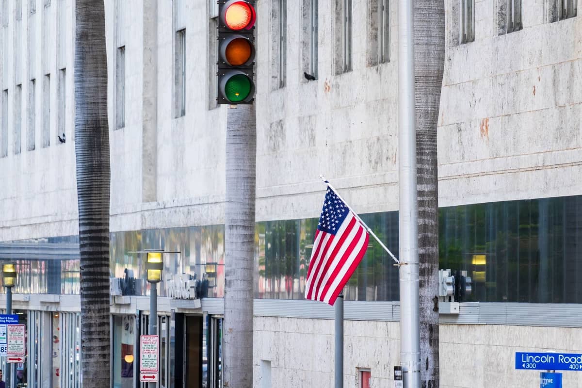 Street scene with Lincoln Road sign, palm trees, and building exterior in South Beach, Miami during the day