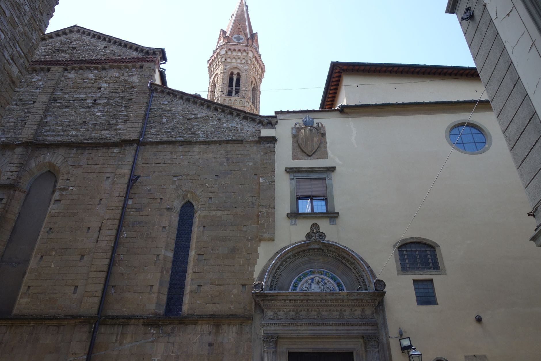 ด้านหน้าของพิพิธภัณฑ์ Bargello พร้อมกำแพงหินยุคกลางและหอระฆังที่มองเห็นอยู่เบื้องหลัง ถ่ายจากถนนแคบๆ ด้านนอก