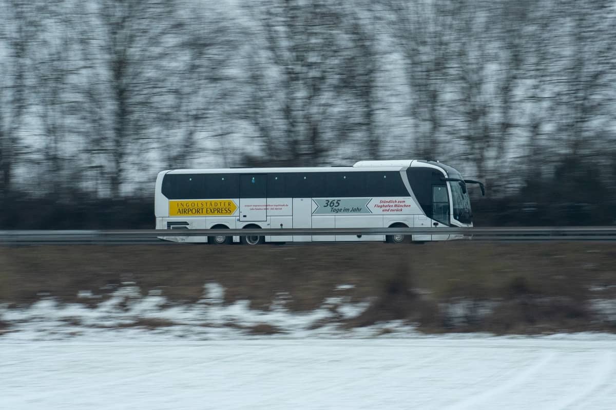 Airport-Express-Bus auf einer Autobahn im Winter, mit gut sichtbarer Flughafenbus-Beschilderung.