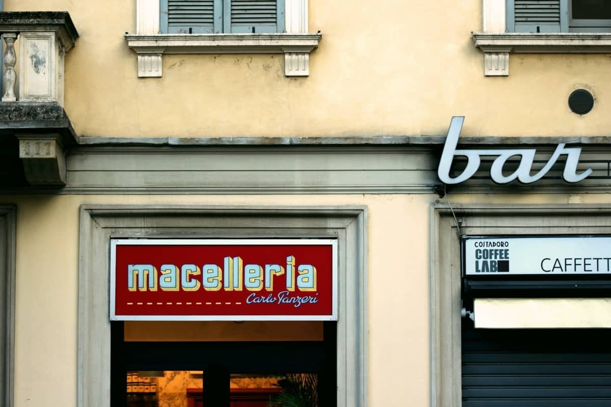 Fachada de una macelleria (carnicería) y bar en una calle de Milán, que muestra la tradición de cocina a base de carne de Lombardía.