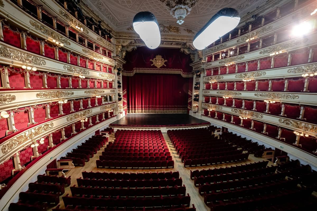 Inneres der prunkvollen rot-goldenen Oper La Scala in Mailand mit leeren Sitzen und der großen Bühne.