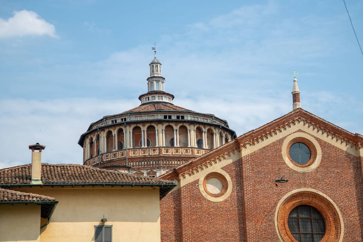 Blick auf die Kuppel und die Backsteinfassade der Kirche Santa Maria delle Grazie in Mailand an einem sonnigen Tag.