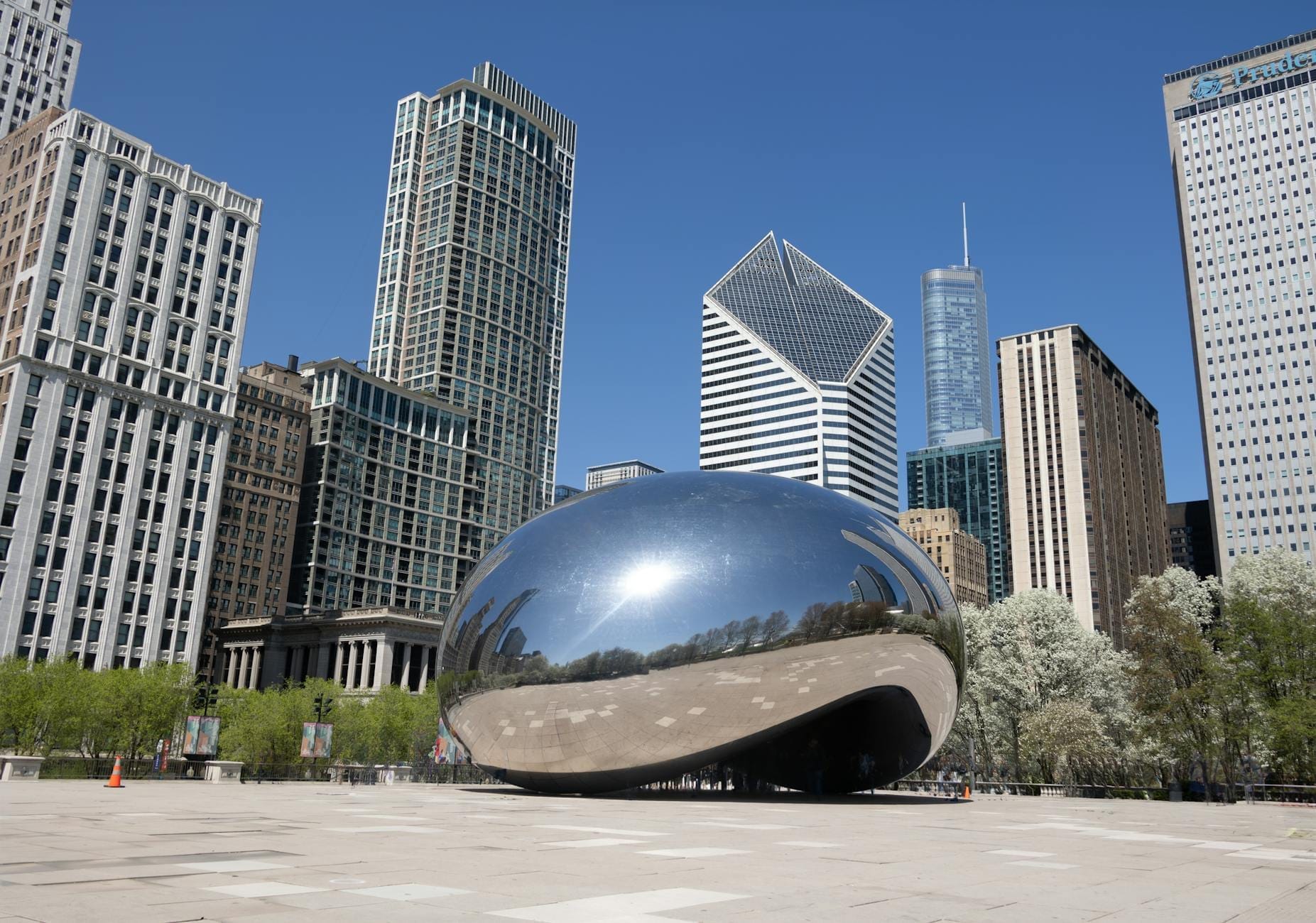 Vista panoramica del Millennium Park di Chicago con la scultura Cloud Gate, circondata dai grattacieli della città in una giornata limpida e soleggiata.