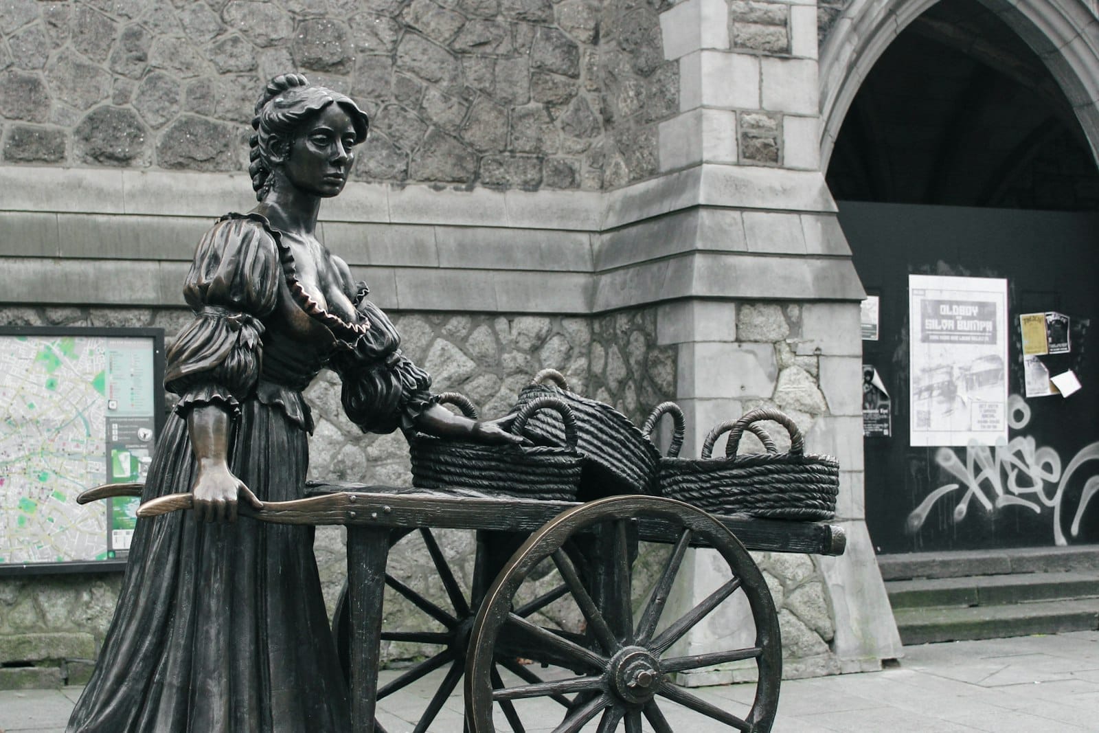La statua in bronzo di Molly Malone con il suo carretto davanti a un edificio in pietra su Suffolk Street, nel centro di Dublino.