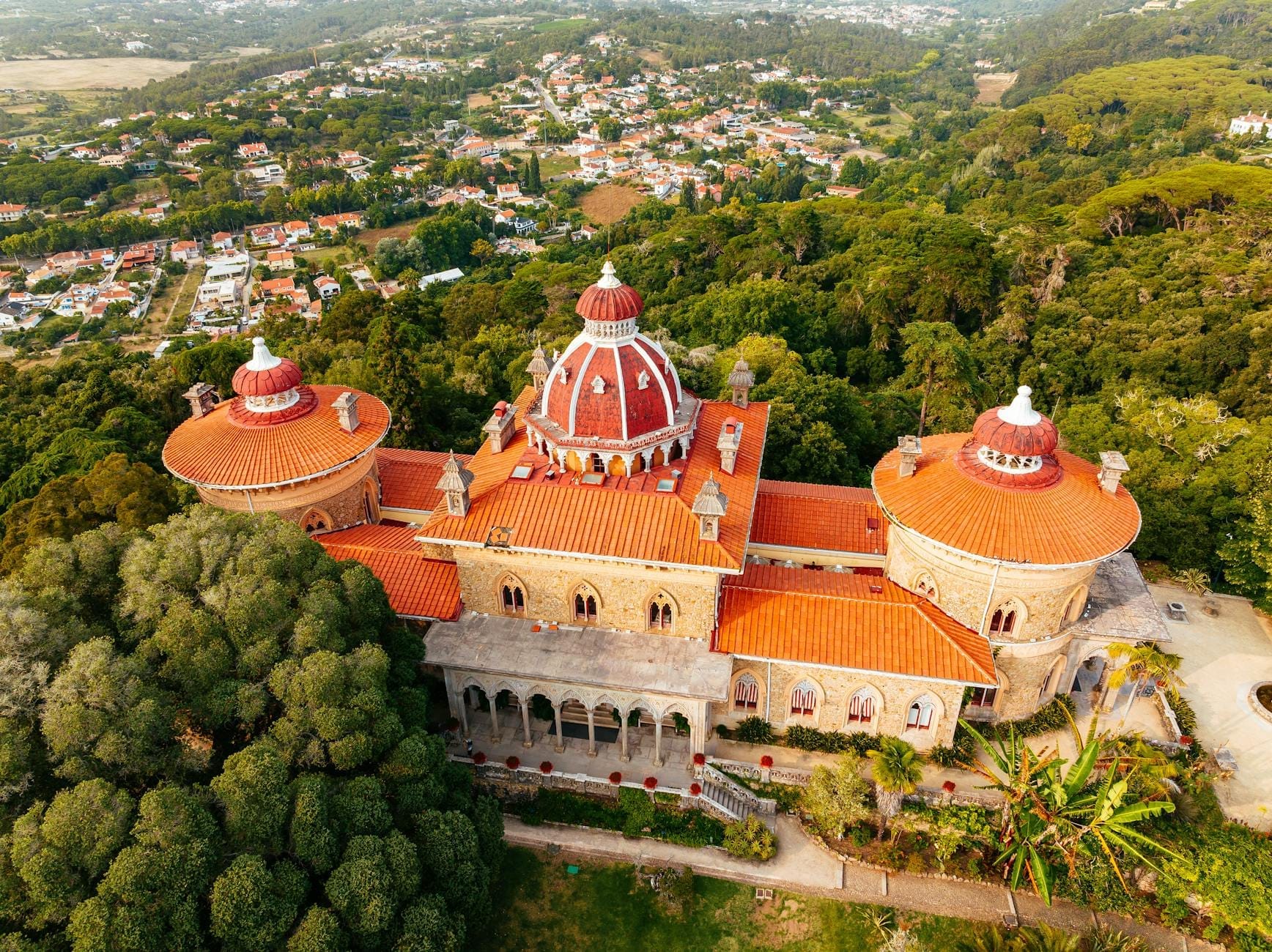 Vista aerea del Palazzo di Monserrate circondato da lussureggianti giardini, con le sue cupole caratteristiche e l'architettura intricata che emergono tra il verde di Sintra.