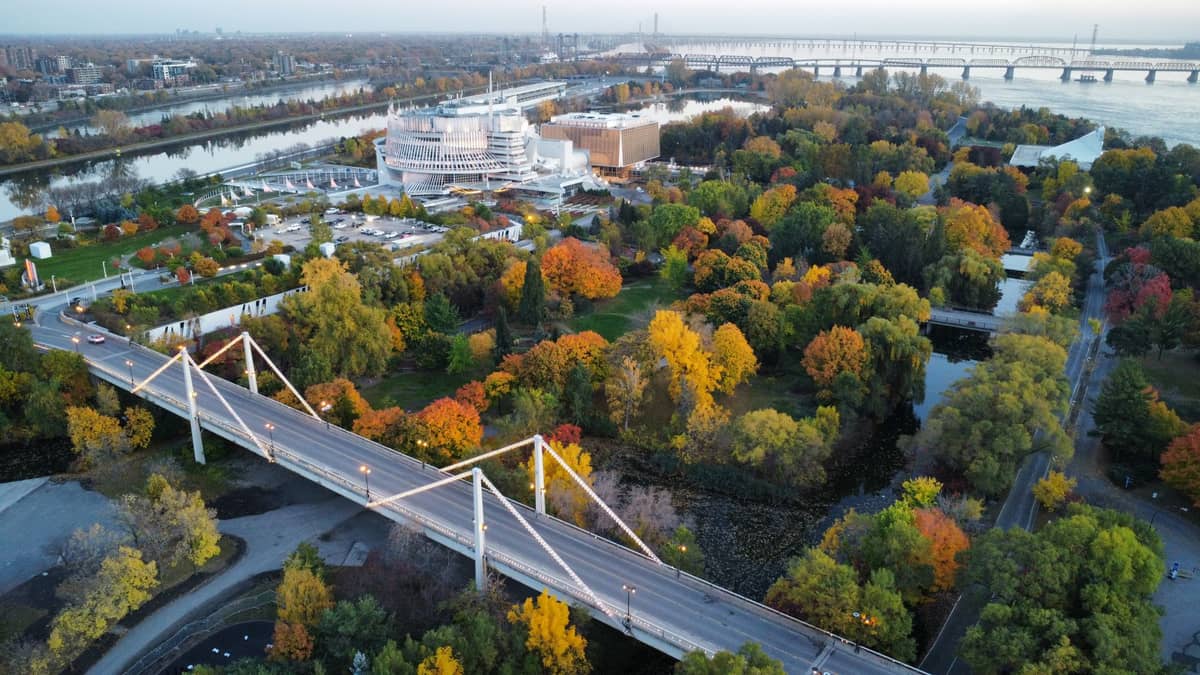 Luftaufnahme des Parc Jean-Drapeau auf der Île Notre-Dame in Montreal mit Bäumen, einer Brücke und dem weißen Casino de Montréal.