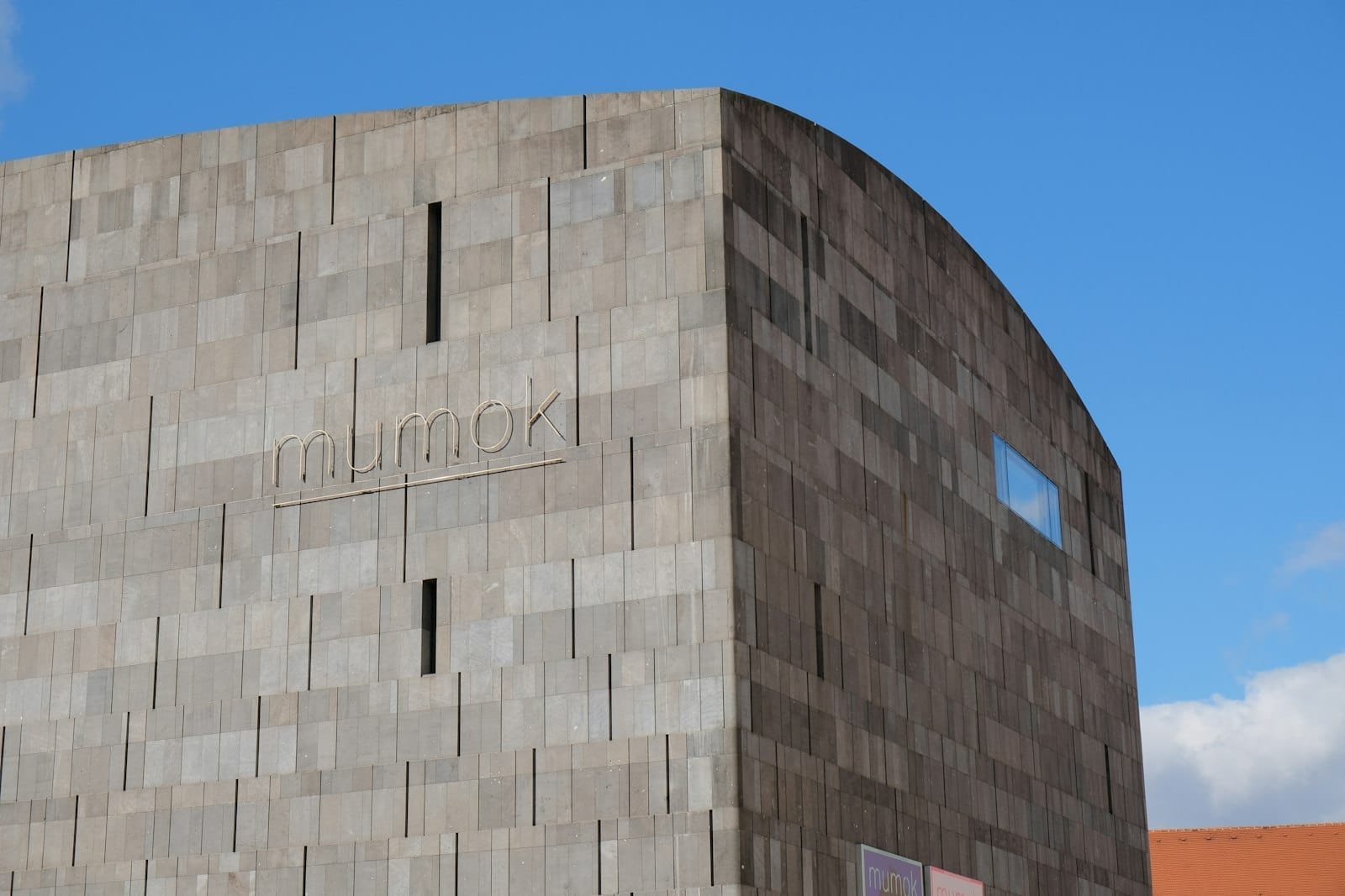 Außenansicht des mumok Museum of Modern Art Vienna mit seiner markanten grauen Basaltfassade unter einem klaren blauen Himmel.