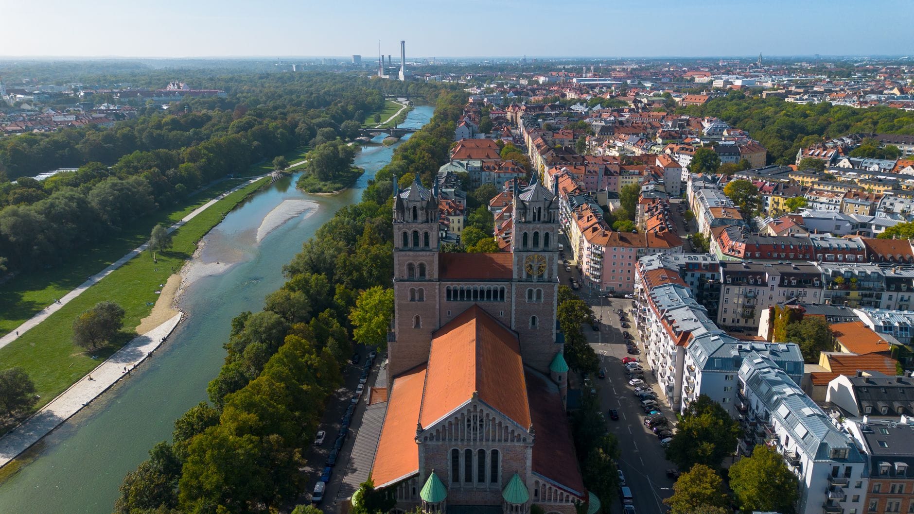 ภาพมุมสูงของโบสถ์ St. Maximilian และแม่น้ำ Isar ในมิวนิก ท่ามกลางสวนเขียวกับย่านชุมชน มุมเมืองที่ไม่เหมือนใคร