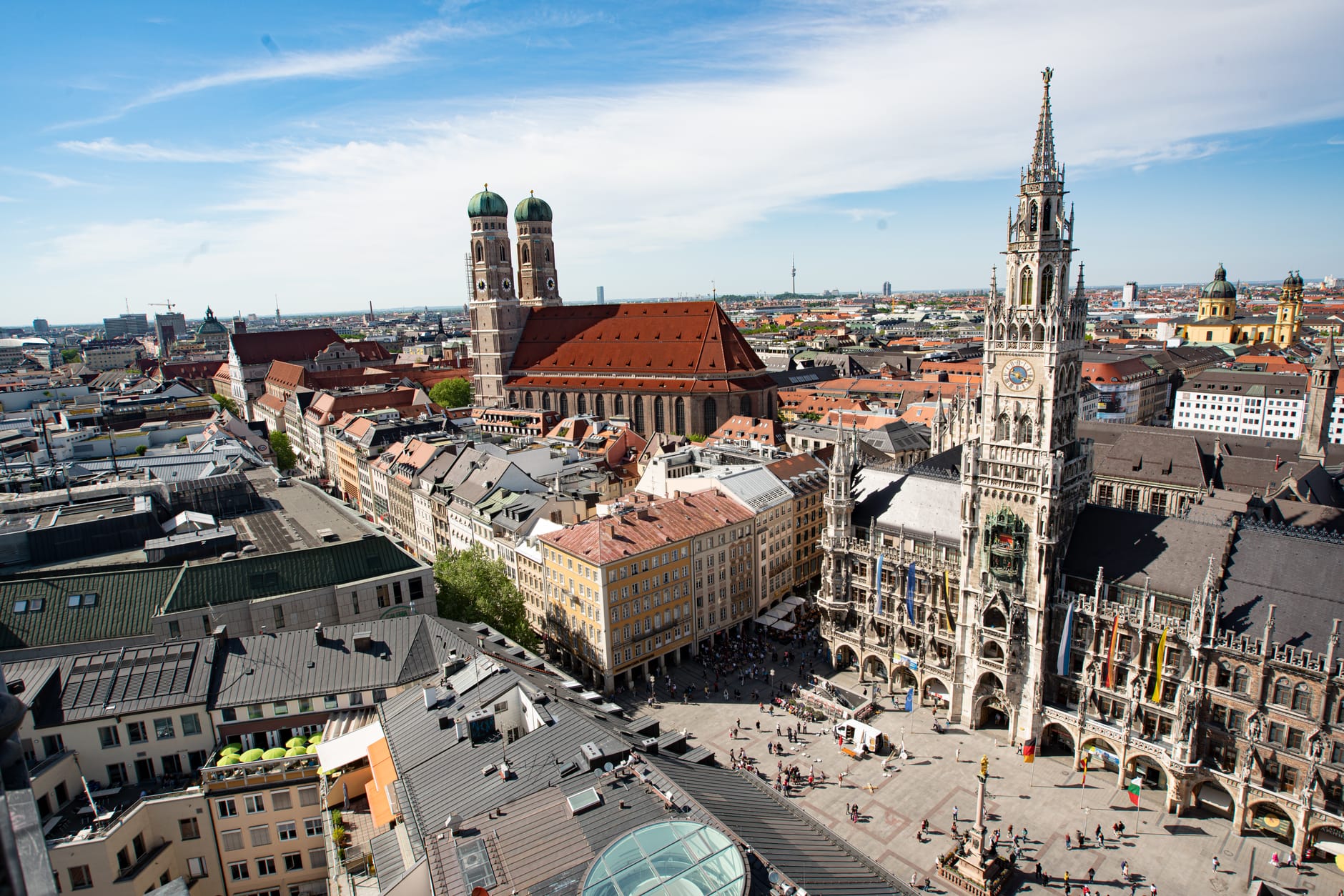ภาพถ่ายทางอากาศของ Marienplatz ใจกลางมิวนิกช่วงวันแดดจ้า มองเห็นศาลาว่าการเมืองใหม่ โดมคู่ Frauenkirche และอาคารประวัติศาสตร์รายรอบ