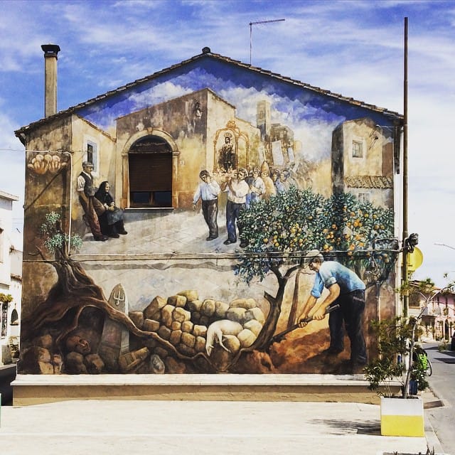 Blick eines Reisenden auf ein mit Wandgemälden geschmücktes Haus in San Sperate, Sardinien