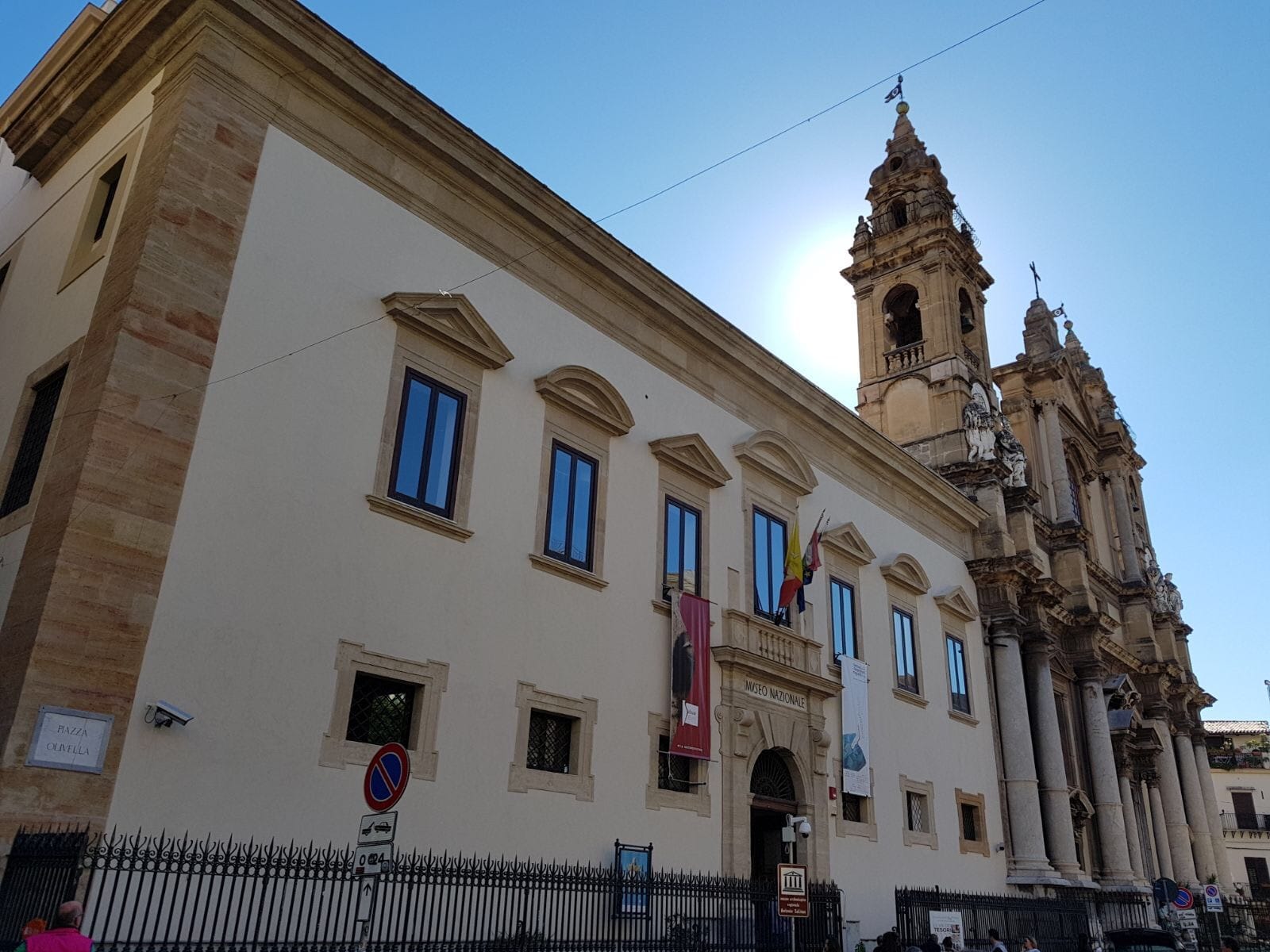 Das Museo Archeologico Regionale Antonino Salinas in Palermo mit seiner prächtigen Fassade aus dem 17. Jahrhundert und den Kirchentürmen vor einem klaren blauen Himmel.