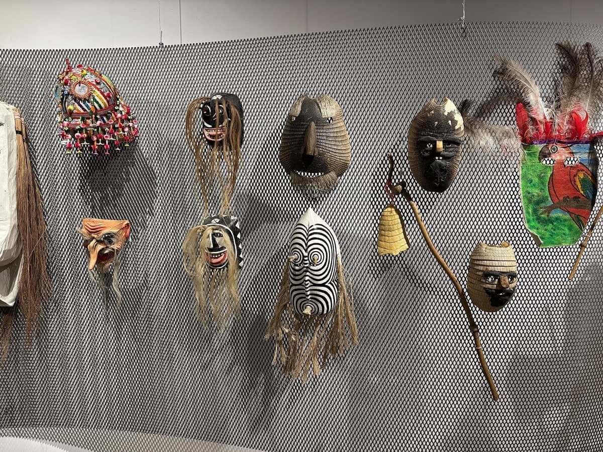 การจัดแสดงหน้ากากและวัตถุโบราณพื้นเมืองหลากสีสันบนผนังตาข่ายภายใน Museo de Arte Precolombino e Indígena ในเมืองมอนเตวิเดโอ