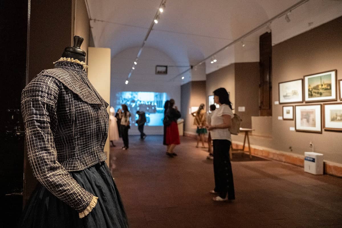 ห้องจัดแสดงนิทรรศการภายใน Museo Histórico Cabildo ที่มีชุดวินเทจบนหุ่นจำลอง งานศิลปะในกรอบบนผนัง และนักท่องเที่ยวที่กำลังสำรวจนิทรรศการ