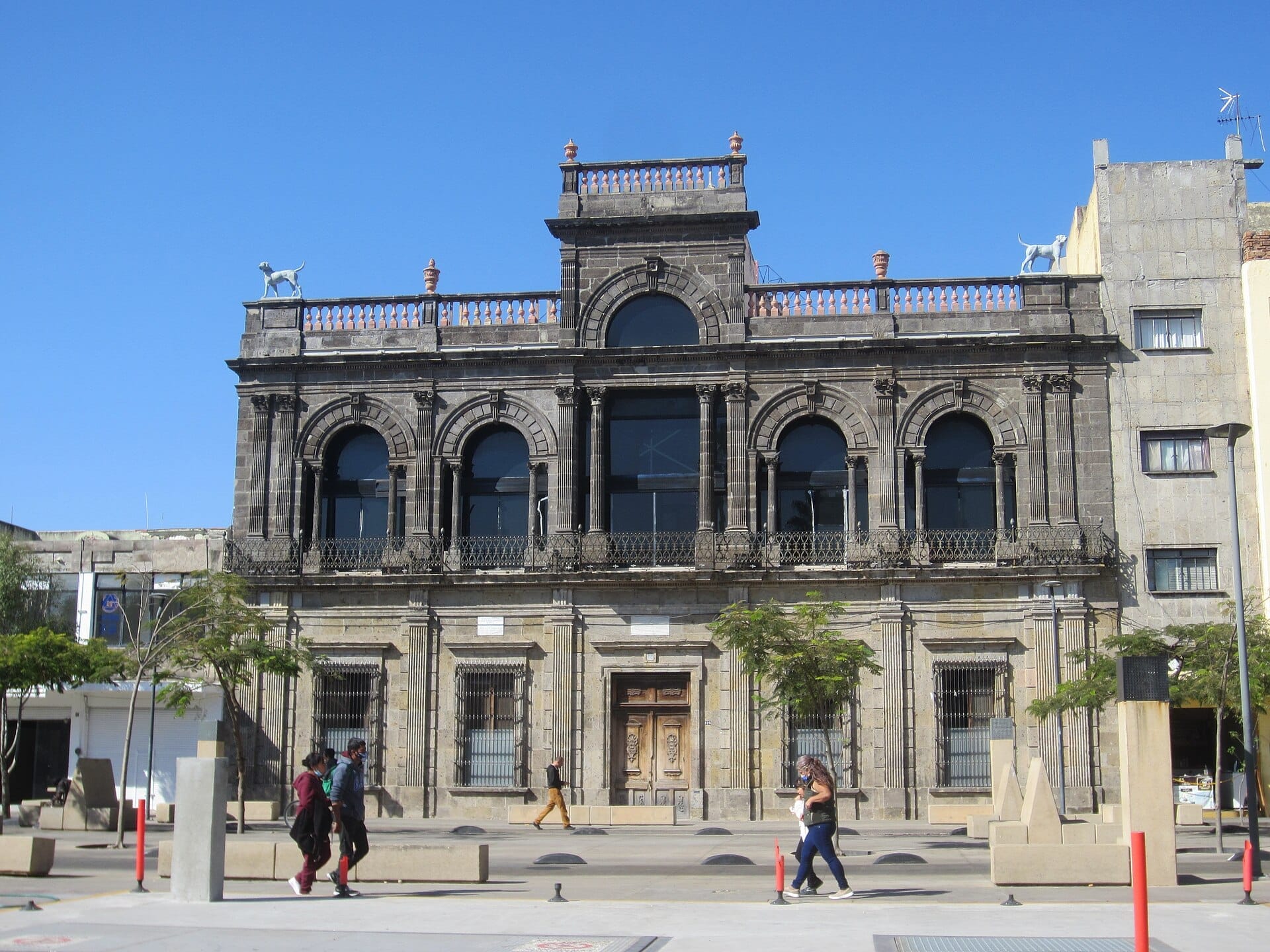 Facciata storica del Museo del Periodismo y las Artes Gráficas a Guadalajara, con finestre ad arco, elaborate lavorazioni in pietra e due cani scolpiti sul tetto.