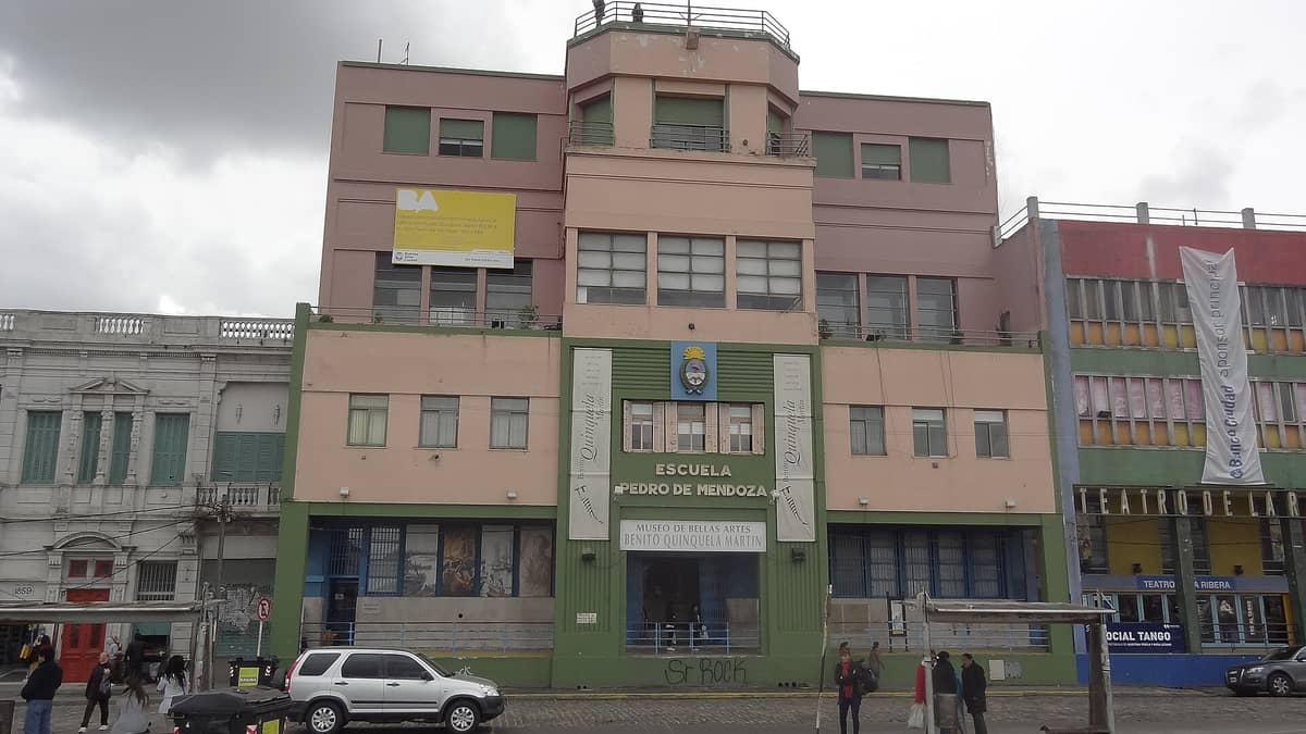 ด้านหน้าพิพิธภัณฑ์ Benito Quinquela Martín ใน La Boca อาคารสีชมพูและเขียวสุดโดดเด่น พร้อมประตูทางเข้าและผู้คนรออยู่ข้างนอก