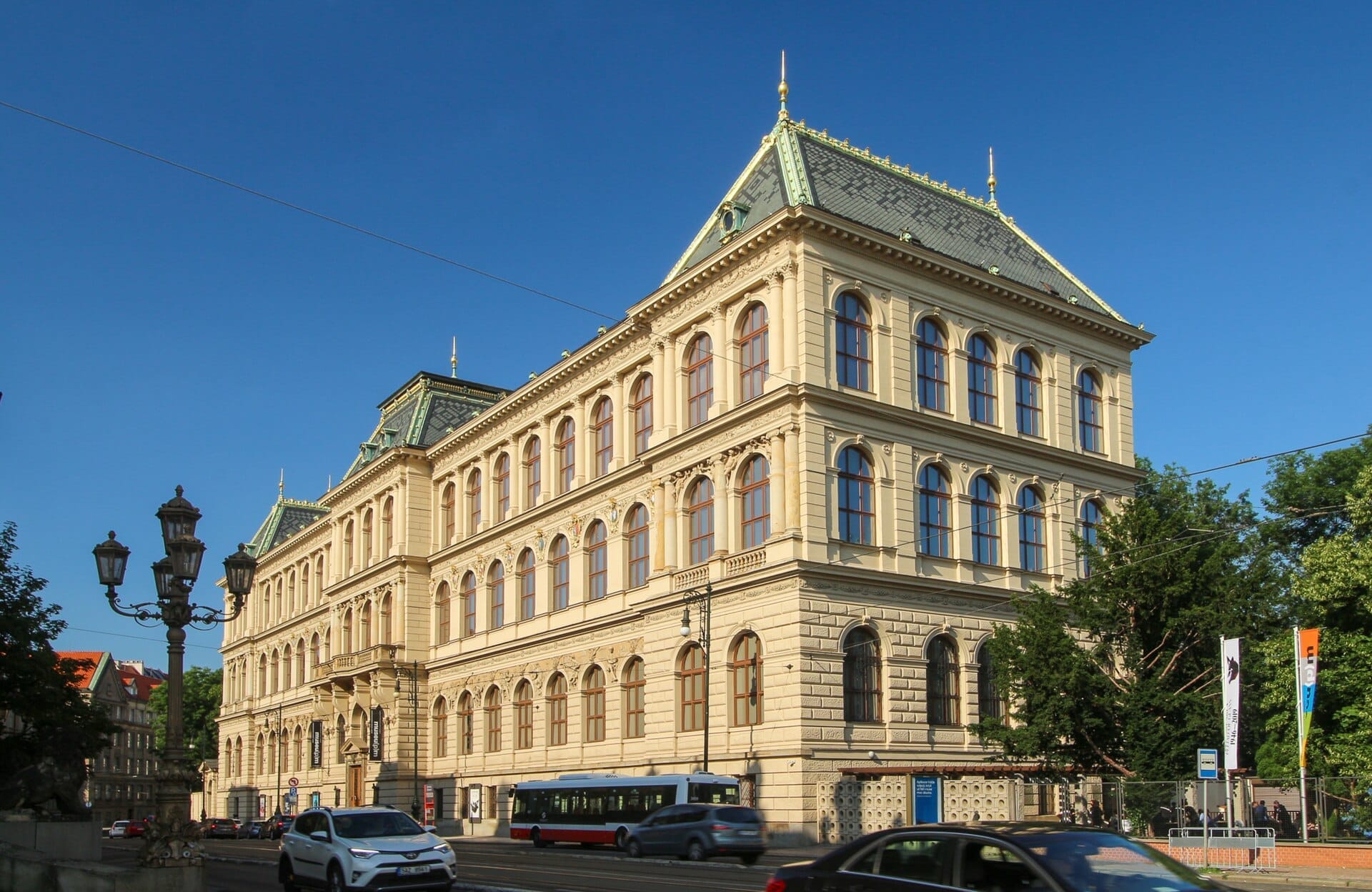 Museum für Dekorative Künste Prag, ein prächtiges neorenaissance Gebäude mit Bogenfenstern, an einem sonnigen Tag mit vorbeifahrendem Verkehr.