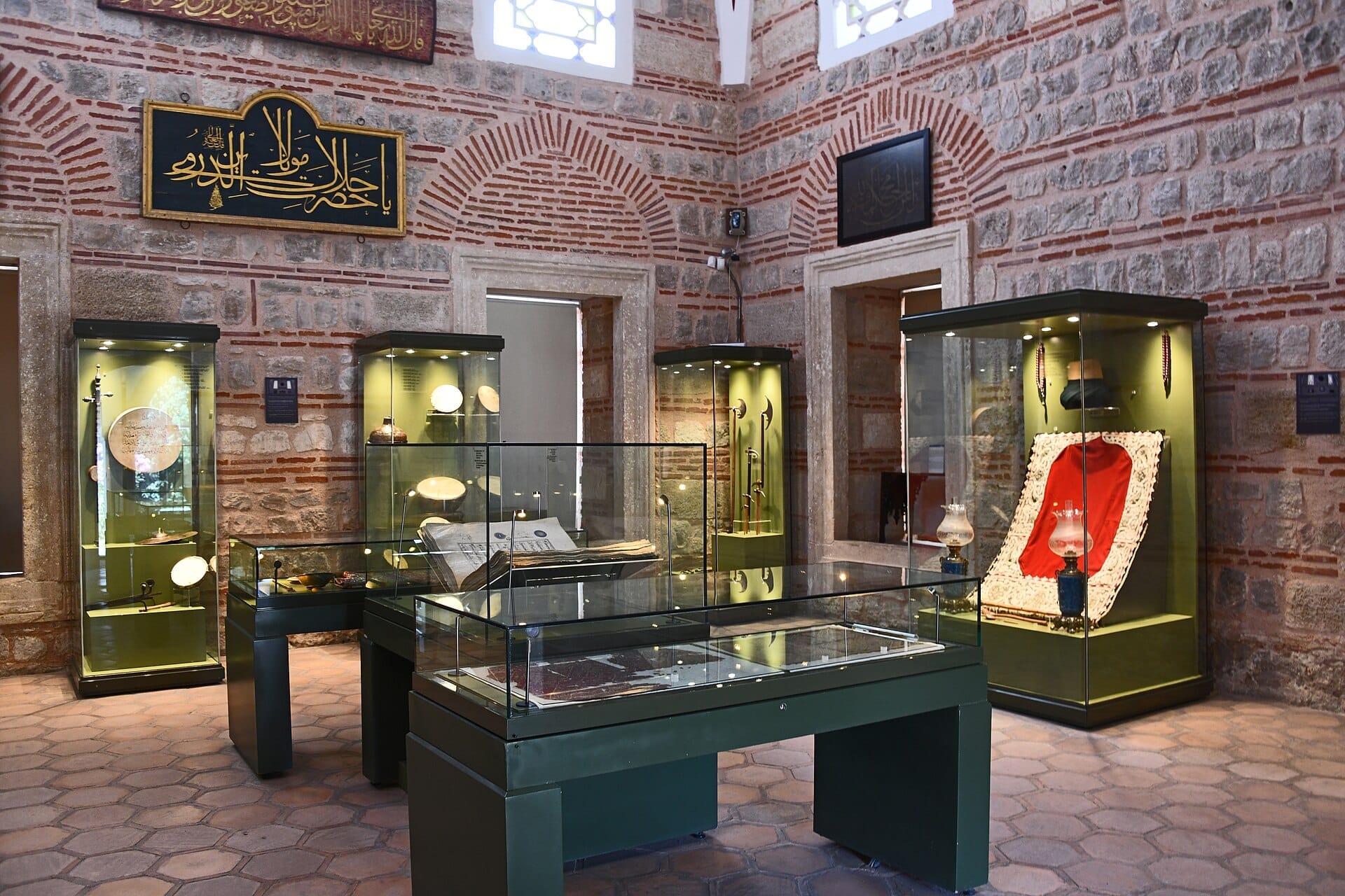 Sala espositiva al Museum of Turkish and Islamic Arts con manufatti in teche di vetro lungo storiche pareti ottomane in pietra e mattoni.