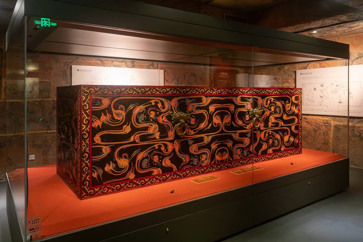 A large, elaborately decorated lacquered coffin belonging to the Nanyue King, displayed in a glass case inside the Museum of the Nanyue King Mausoleum in Guangzhou.