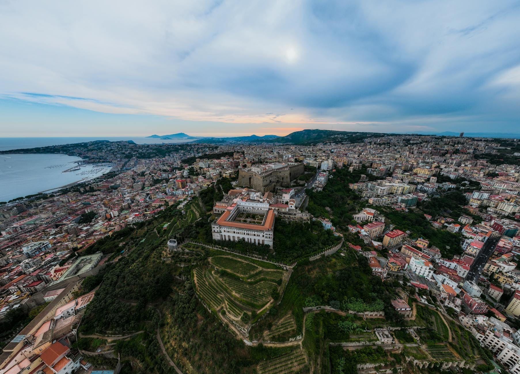 Vue aérienne des collines de Naples avec le Castel Sant'Elmo et la Certosa di San Martino surplombant la ville et la baie au coucher du soleil