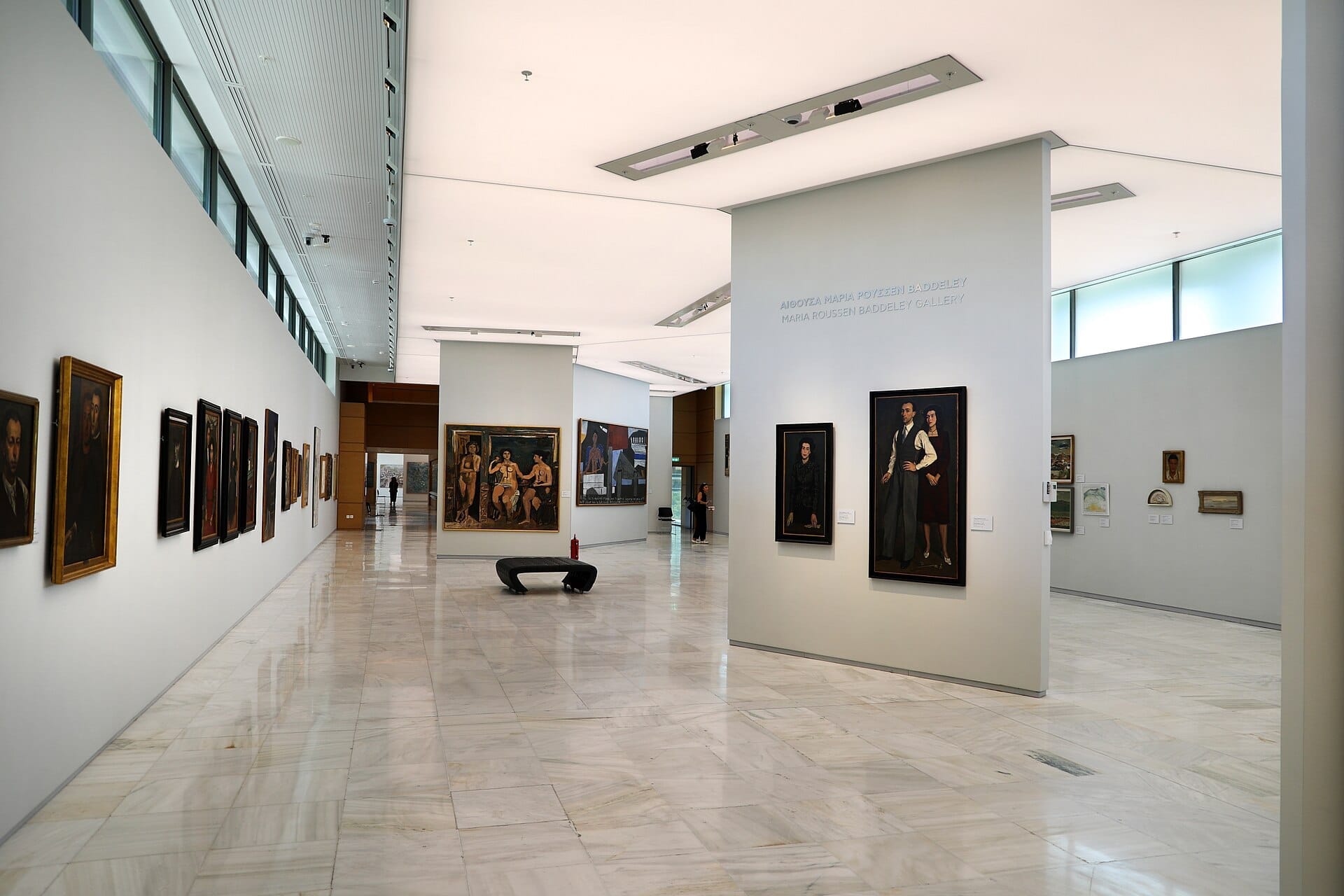 Interno spazioso e luminoso del National Gallery – Alexandros Soutsos Museum con pareti bianche moderne e dipinti di ritratti greci in esposizione.