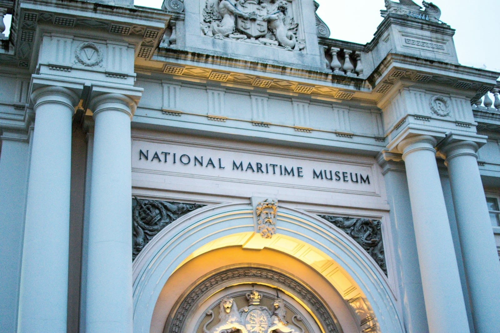 Ingresso principale del National Maritime Museum a Greenwich, con maestose colonne, intagli in pietra e illuminazione serale.