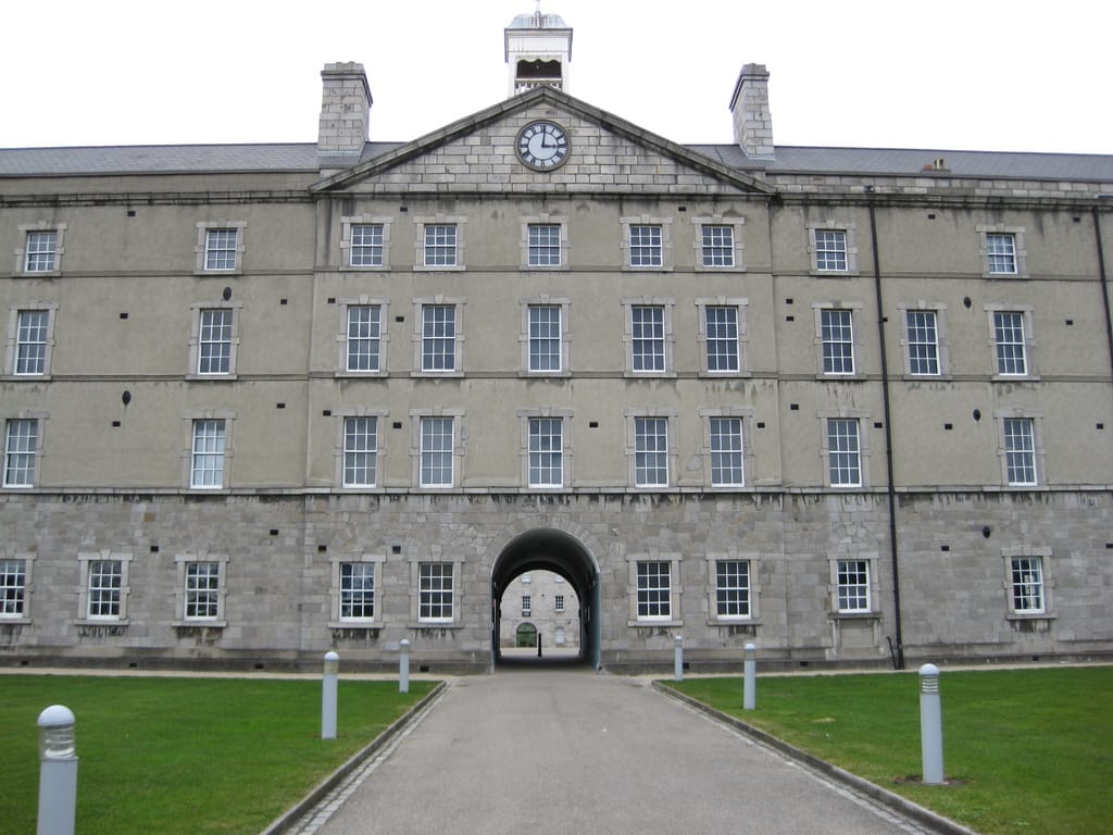 Vista frontale del National Museum of Ireland – Decorative Arts & History, che mostra lo storico edificio Collins Barracks con finestre simmetriche e un arco centrale.