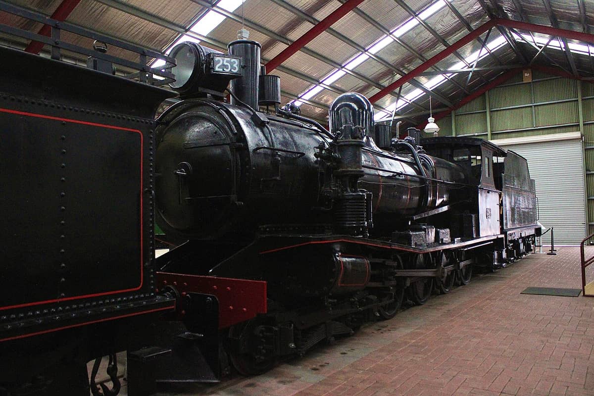 Wide view of a preserved black steam locomotive 253 displayed indoors under the large tin roof of the National Railway Museum in Port Adelaide, Australia.