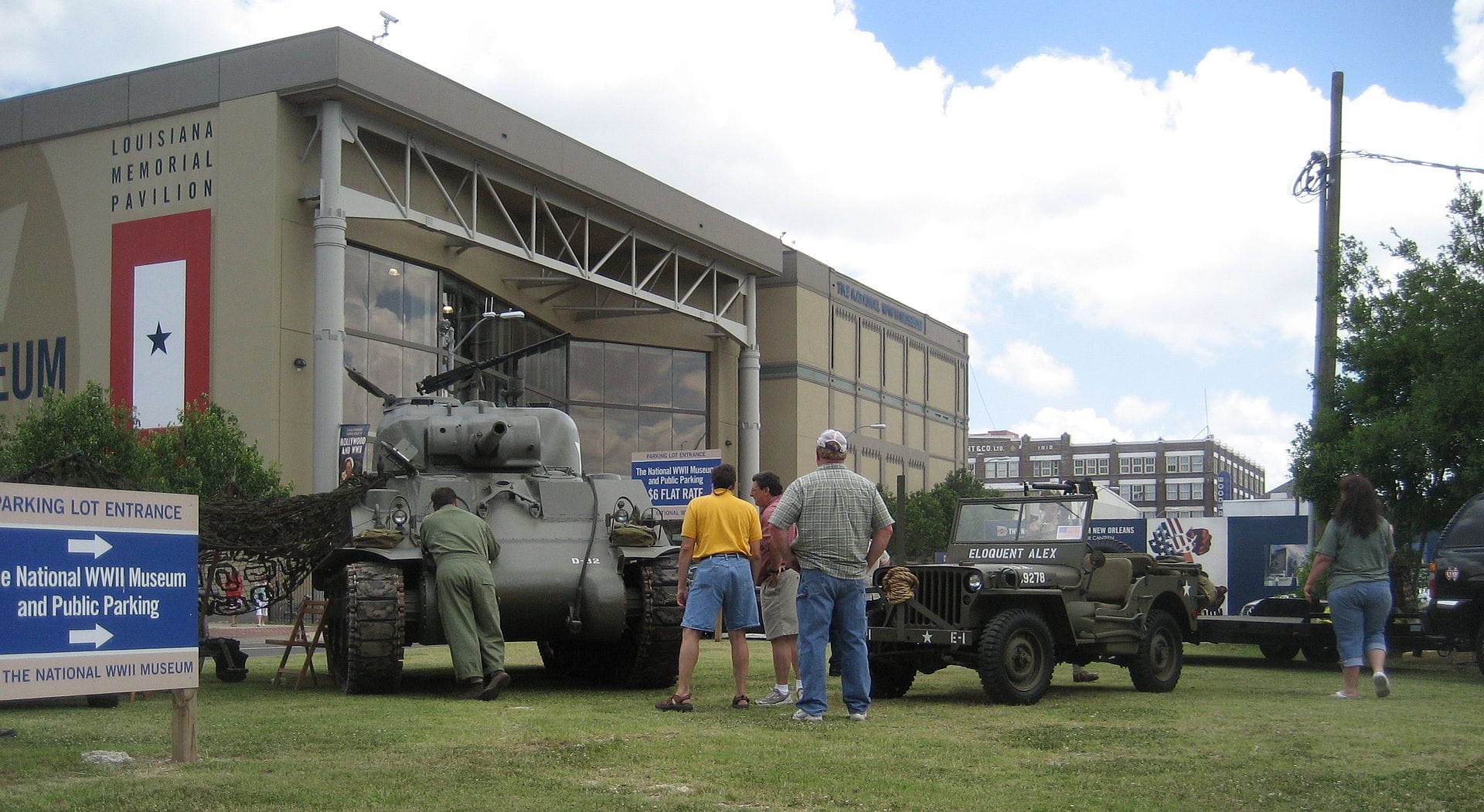I visitatori si riuniscono attorno a un carro armato e una jeep storici esposti all'esterno del Louisiana Memorial Pavilion del National WWII Museum in una giornata di sole a New Orleans.