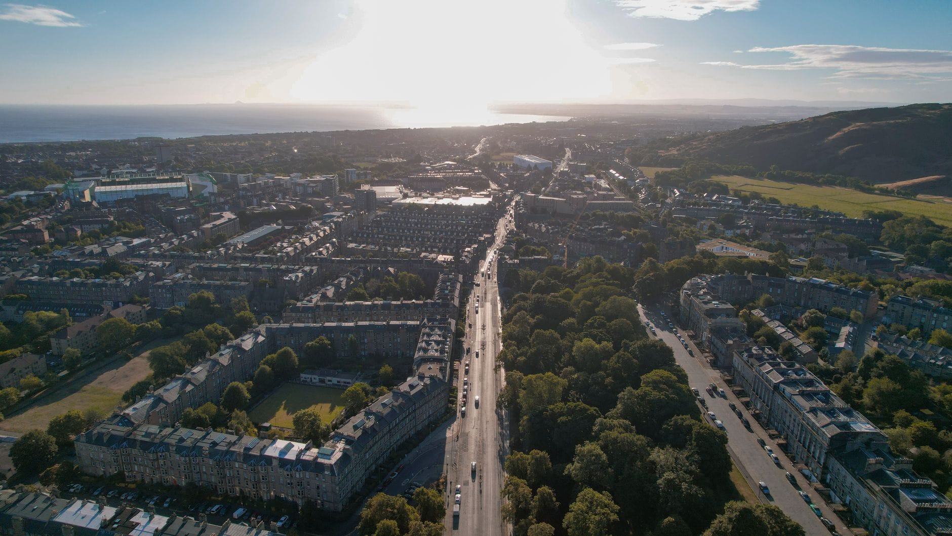 Luftaufnahme von Edinburghs New Town mit georgianischen Terrassen und einem breiten Boulevard in Richtung Stadtzentrum, aufgenommen bei Sonnenschein.