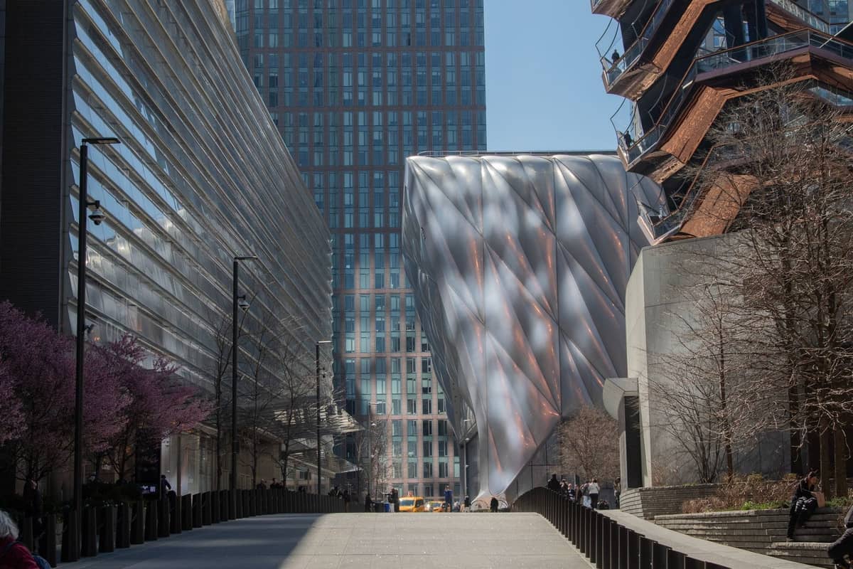 Modernes silbernes Gebäude des Kunstzentrums The Shed in Hudson Yards, umgeben von Wolkenkratzern und The Vessel in New York City.