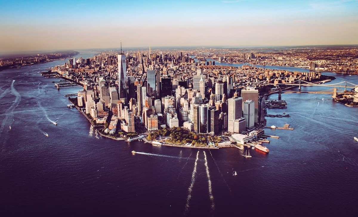 Luftaufnahme von Lower Manhattan, umgeben von Flüssen, die die einzigartige Bezirksgeographie von New York City und die Skyline an einem klaren Tag zeigt.