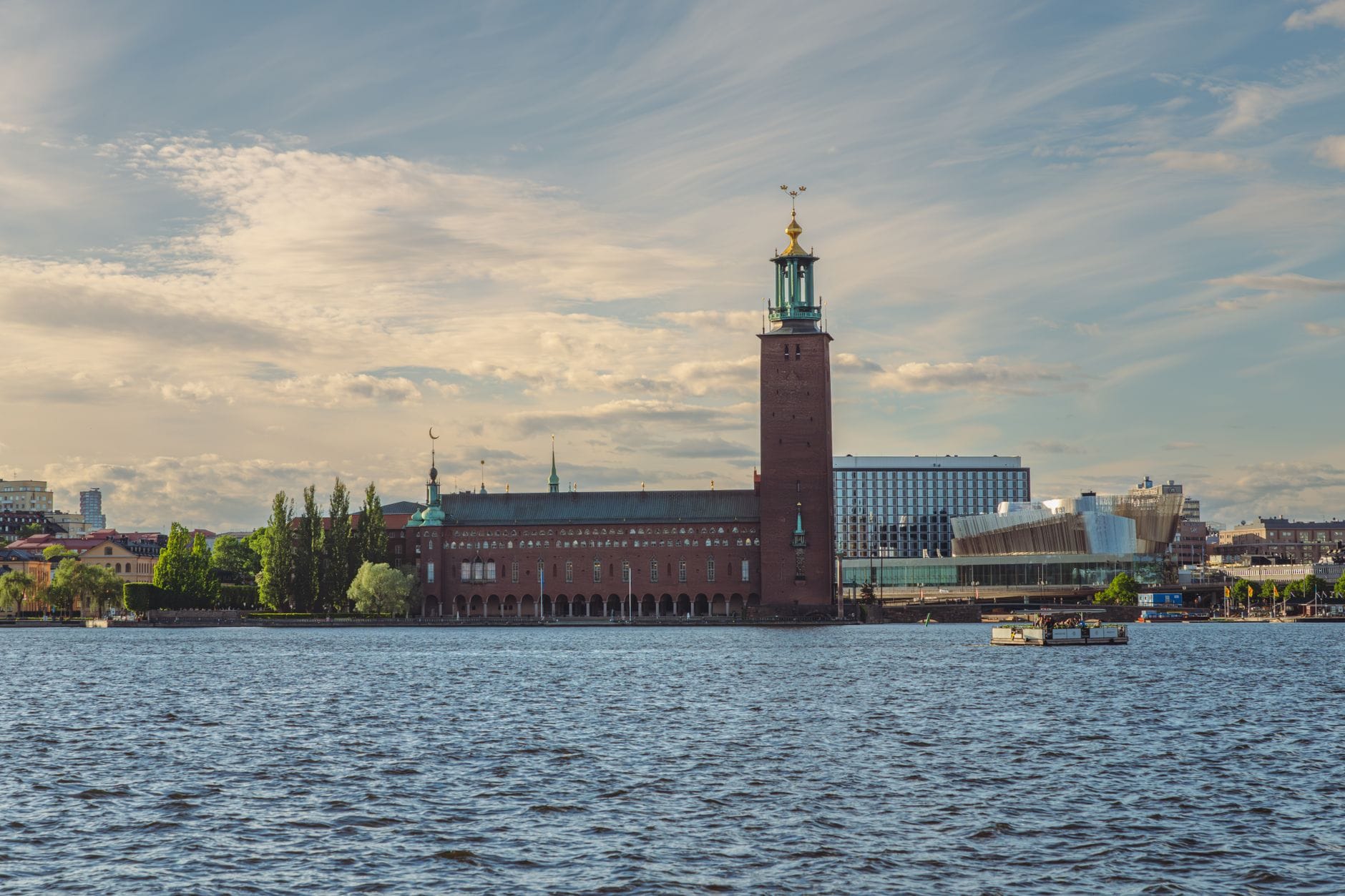 Stockholm City Hall มองเห็นข้ามน้ำในวันที่อากาศแจ่มใสและมีเมฆบางส่วน