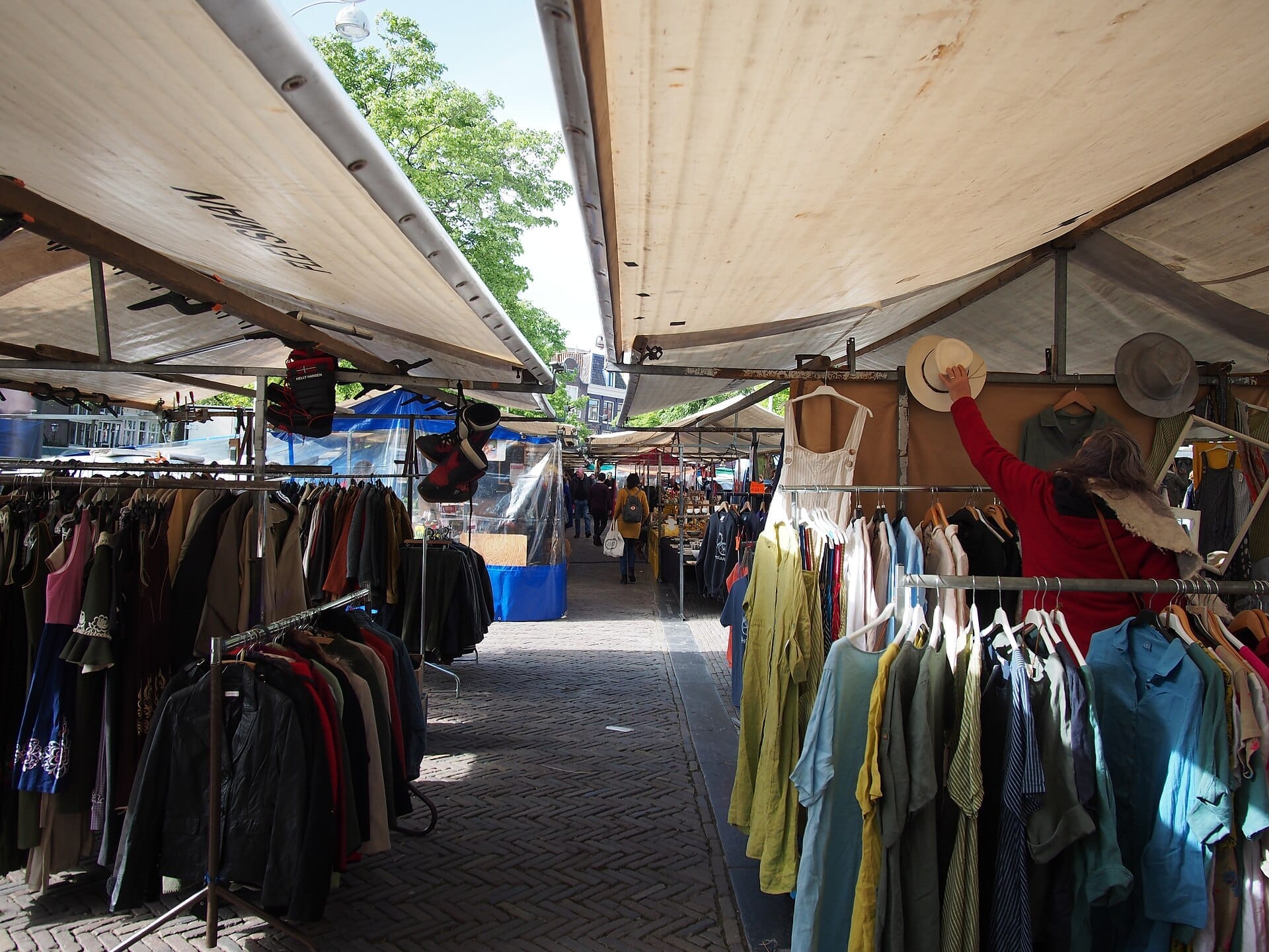 Các gian hàng đầy quần áo sắc màu, áo khoác và mũ nón xếp hàng dọc quảng trường Noordermarkt nhộn nhịp ở Amsterdam dưới những mái hiên rộng rãi tràn ngập ánh nắng.