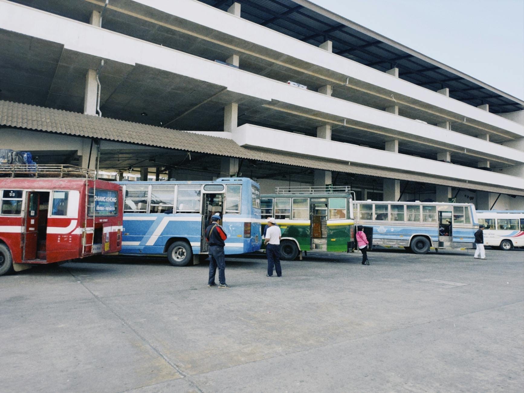 Các hàng xe buýt và người chờ đợi bên ngoài một bến xe buýt lớn, hiện đại, có thể ở Chiang Mai, Thái Lan.