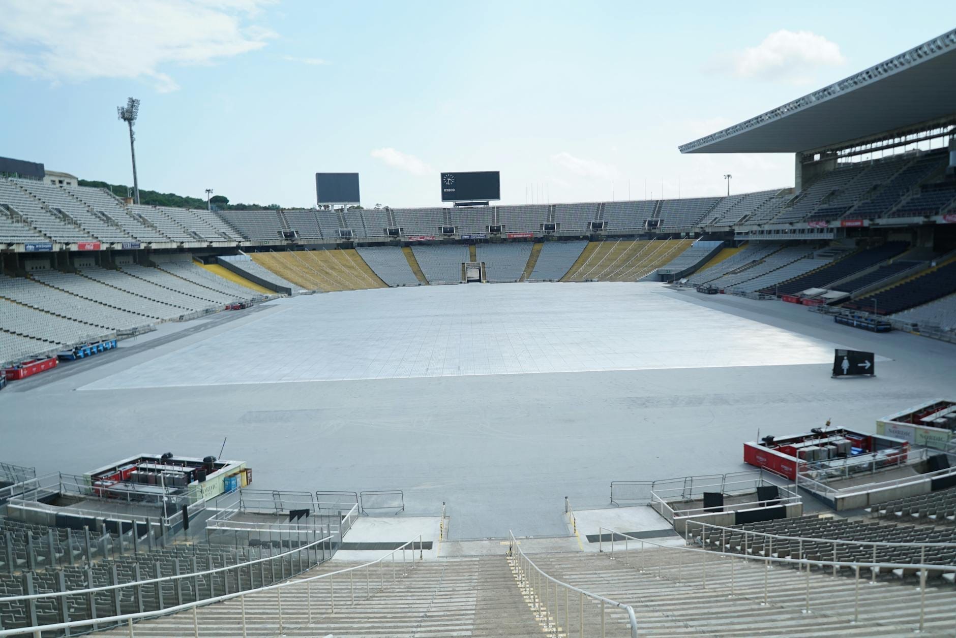 Wide view of Estadi Olímpic Lluís Companys stadium in Barcelona with empty stands, open sky, and partial athletic field, evoking its Olympic legacy.
