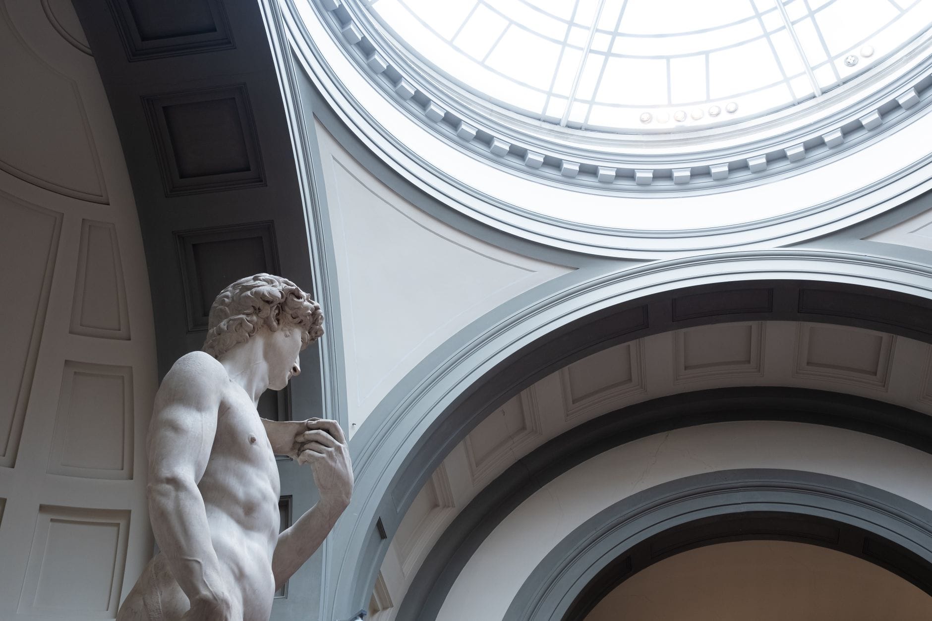 รูปปั้น David ของ Michelangelo ใต้โดมช่องแสงบนเพดานใน Galleria dell'Accademia เมือง Florence พร้อมรายละเอียดทางสถาปัตยกรรมด้านบน