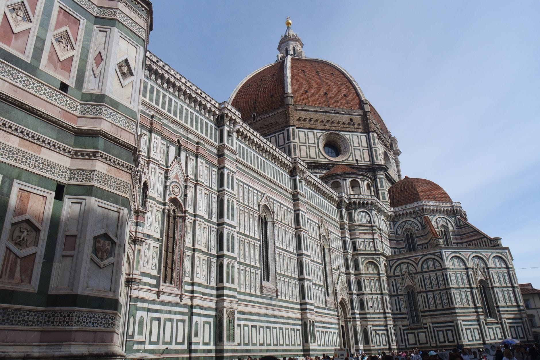 มุมมองแนวนอนกว้างของมหาวิหาร Santa Maria del Fiore ในเมืองฟลอเรนซ์ พร้อมโดมอันโดดเด่นและด้านหน้าอาคารที่ประณีตใต้ท้องฟ้าแจ่มใส