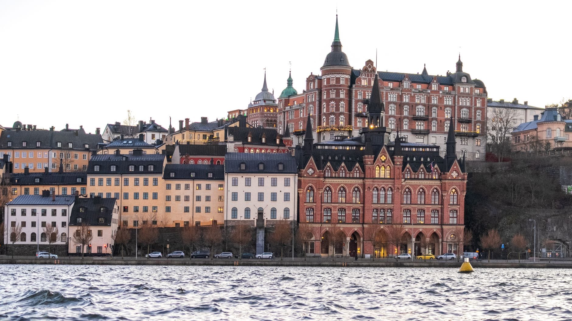 วิวยามเย็นอันงดงามของริมน้ำ Södermalm พร้อมอาคารสีสันประวัติศาสตร์และน้ำในเบื้องหน้า สตอกโฮล์ม