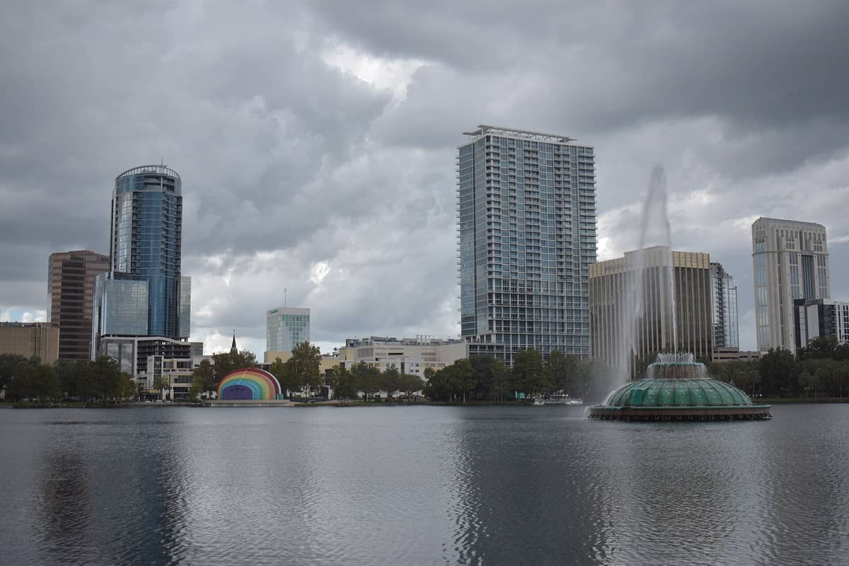 Skyline von Orlando mit dem Brunnen des Lake Eola unter bewölktem Himmel, das typische Wetter vor der Ankunft veranschaulichend.
