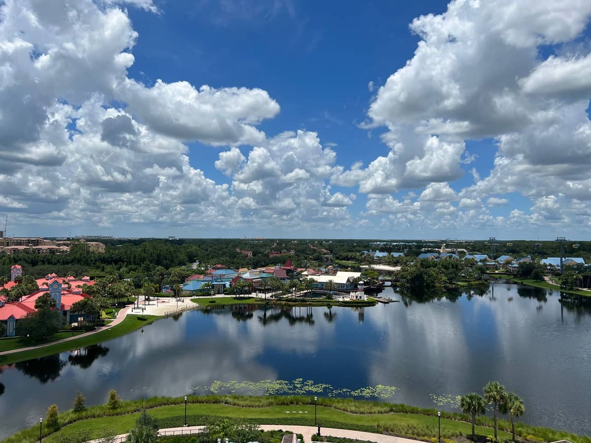 Aerial view of lakes, greenery, and resort rooftops in Orlando under a dramatic blue sky with scattered clouds, showcasing Orlando’s diverse landscape beyond Disney.