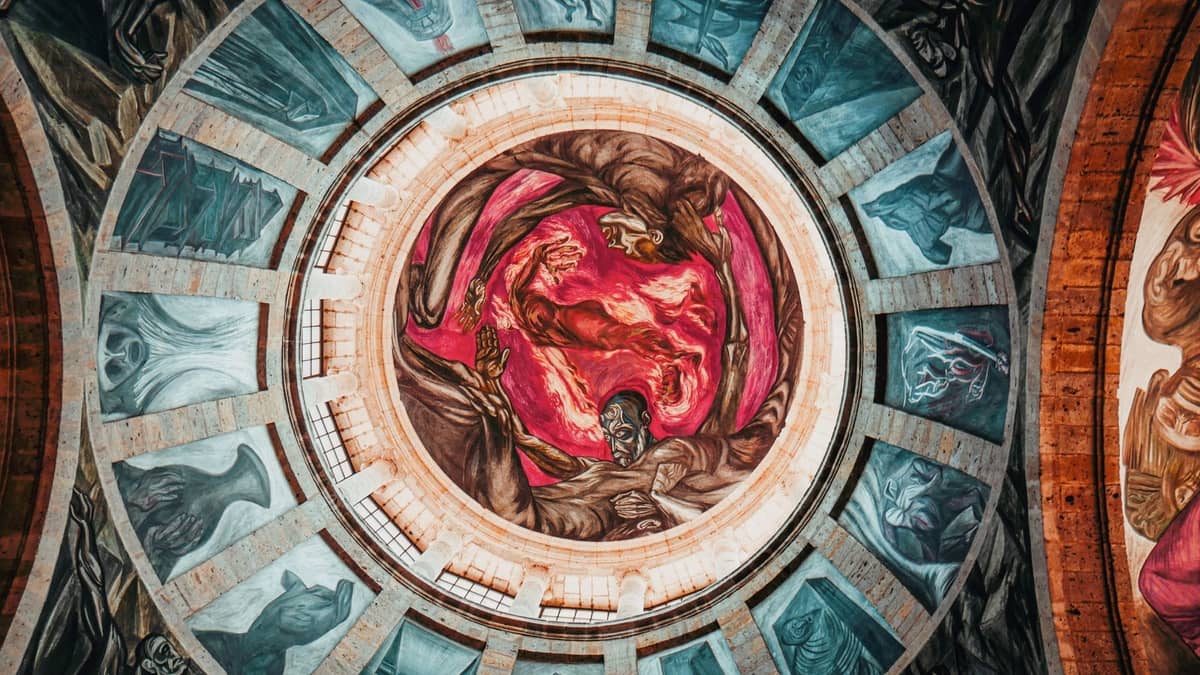Blick von unten auf die Kuppel des Hospicio Cabañas in Guadalajara, bedeckt mit dramatischen Wandgemälden von José Clemente Orozco, mit intensiven Farben und monumentalen Figuren.